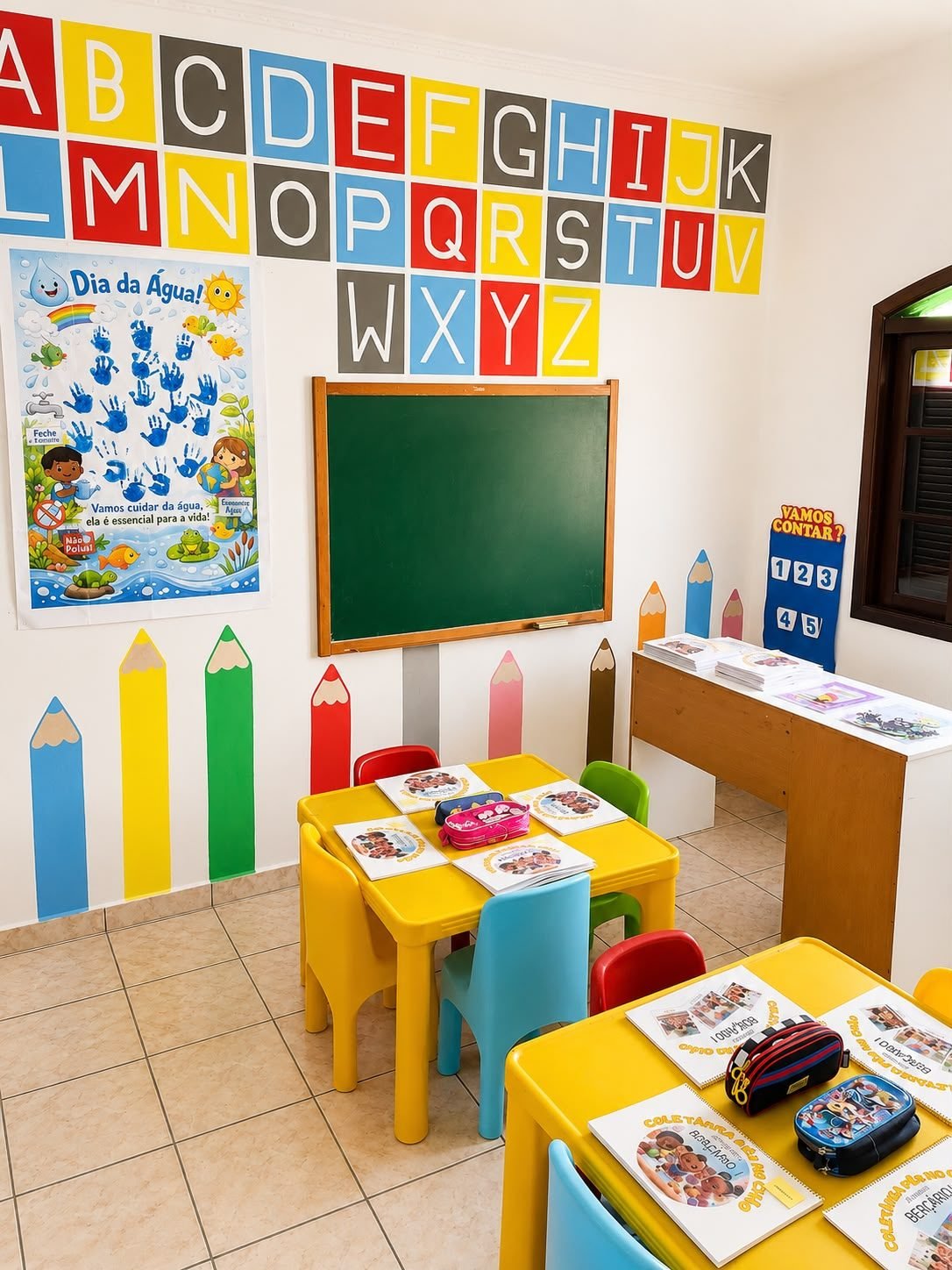 Sala de atividades com mesinhas e lousa
