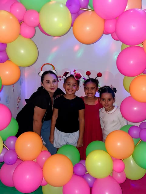 Três meninas com tiaras divertidas ao lado da professora